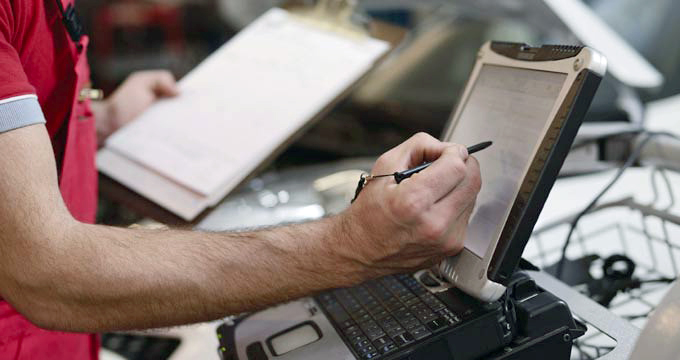Ein Mann bedient am Arbeitsplatz einen Computer mit einem Eingabestift.